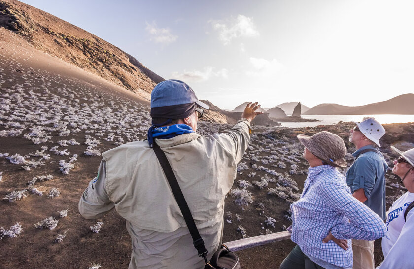 Guide points to the pinnacle rock at Bartolome Island Galapagos
