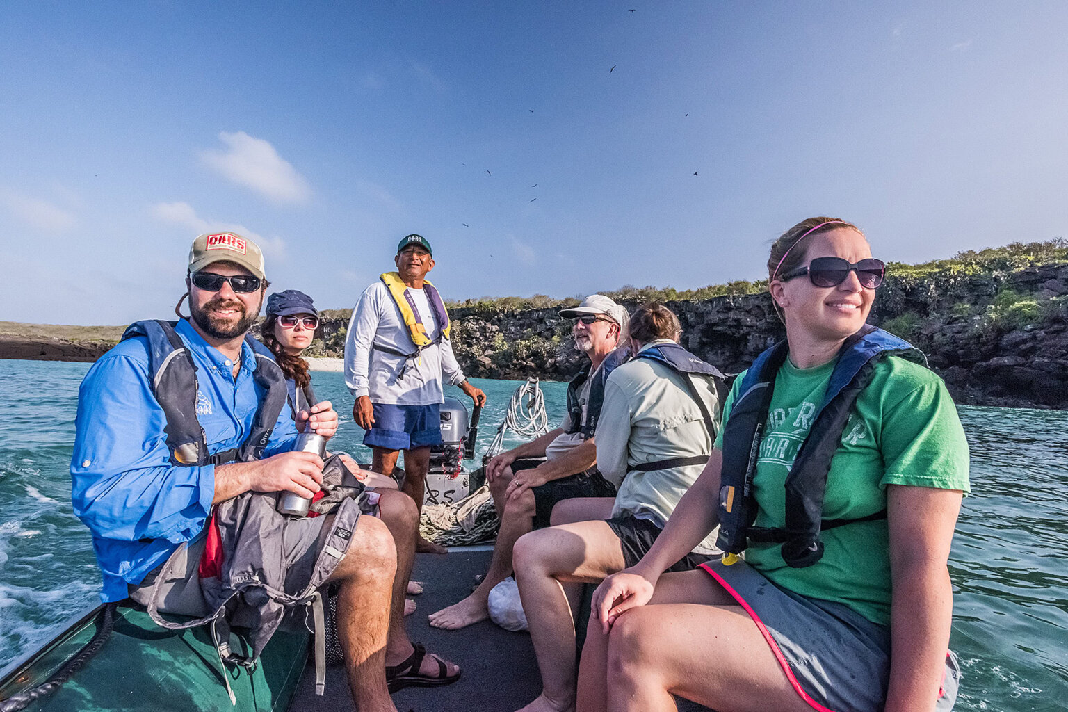 5 guests and a guide at the motor in a panga - Galapagos Islands