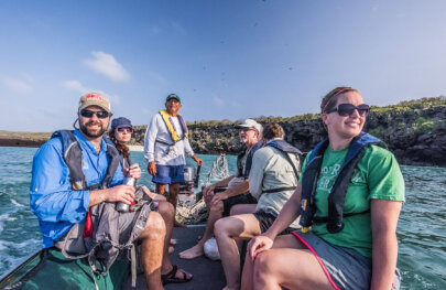 5 guests and a guide at the motor in a panga - Galapagos Islands