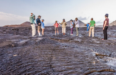 Guide explains "this was lava" as group stands on acres of bumpy dried lava, Galapagos Islands