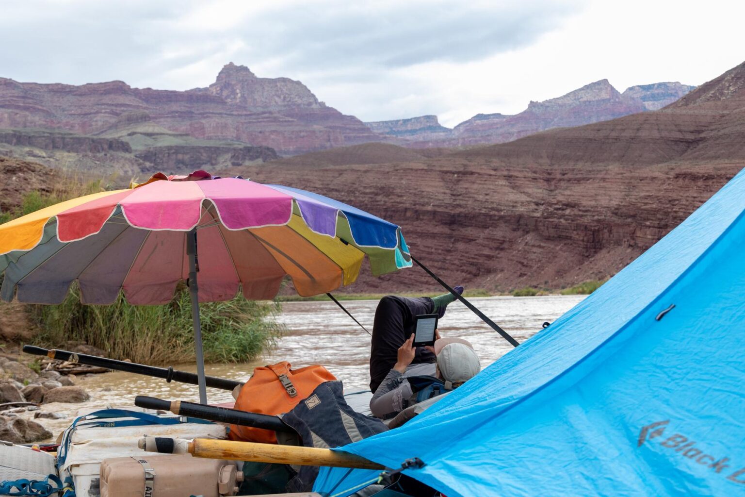 A river guide reading a Kindle in the Grand Canyon
