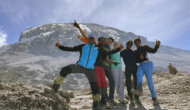 A group celebrates as they approach the summit of Mount Kilimanjaro