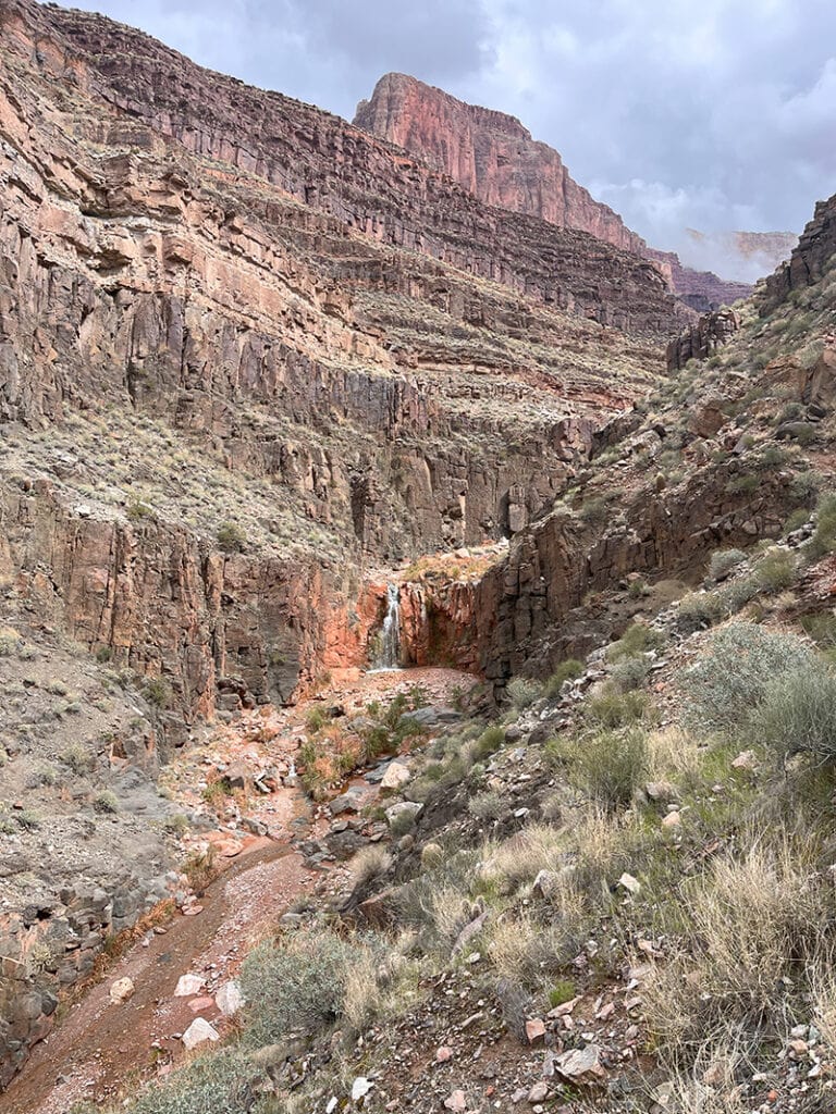 A small waterfall spills down a narrow canyon in Grand Canyon