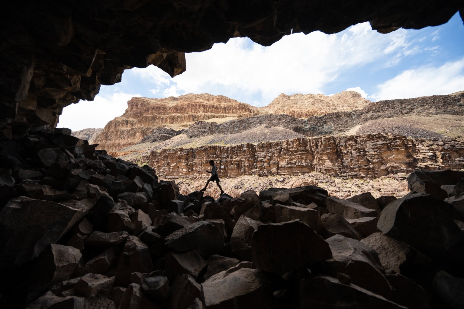 A kid hikes on craggy rocks