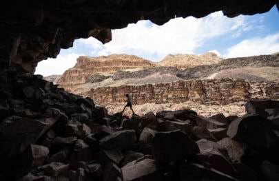 A kid hikes on craggy rocks