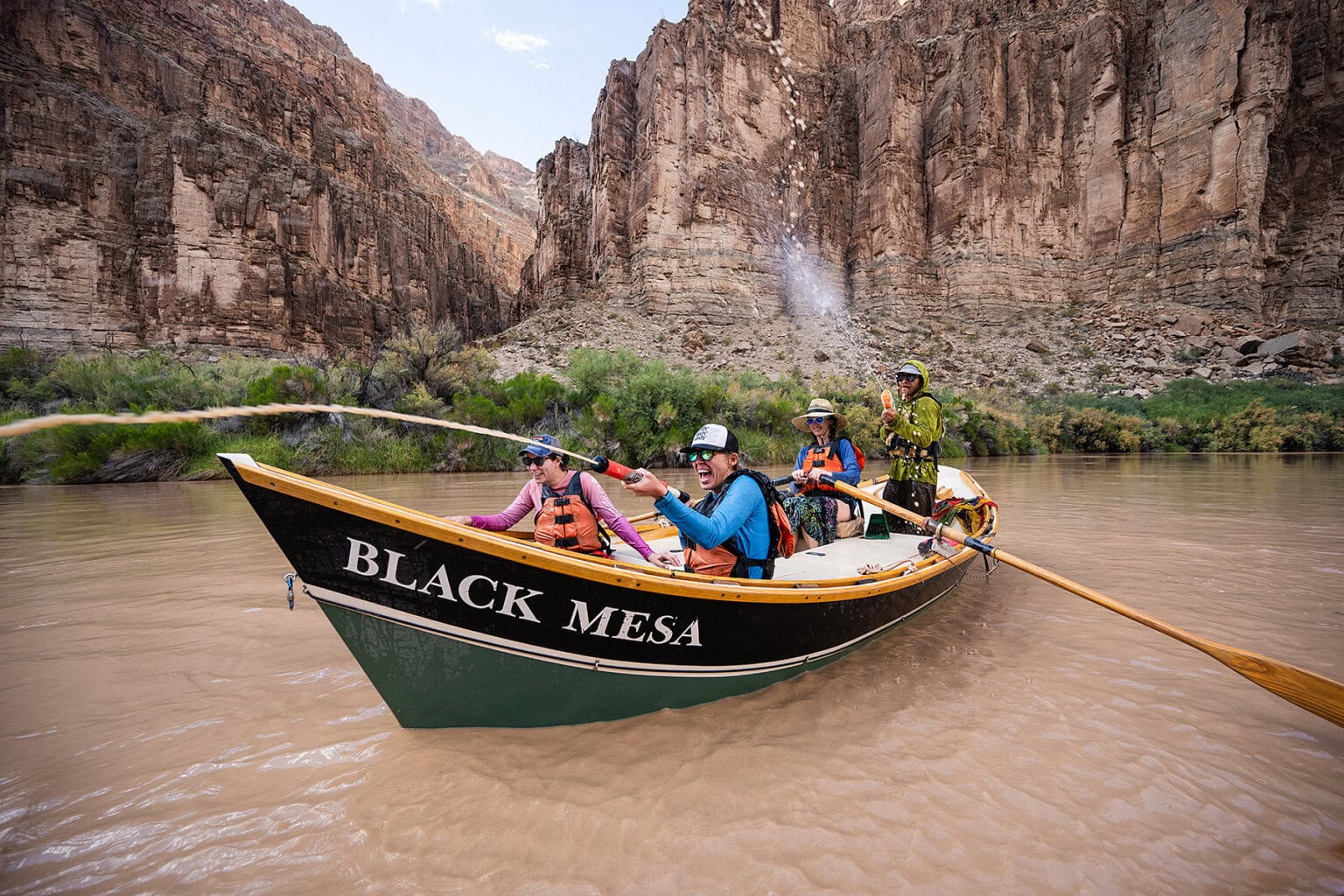 Guests in a dory engage in a water gun fight on the Colorado River in Grand Canyon