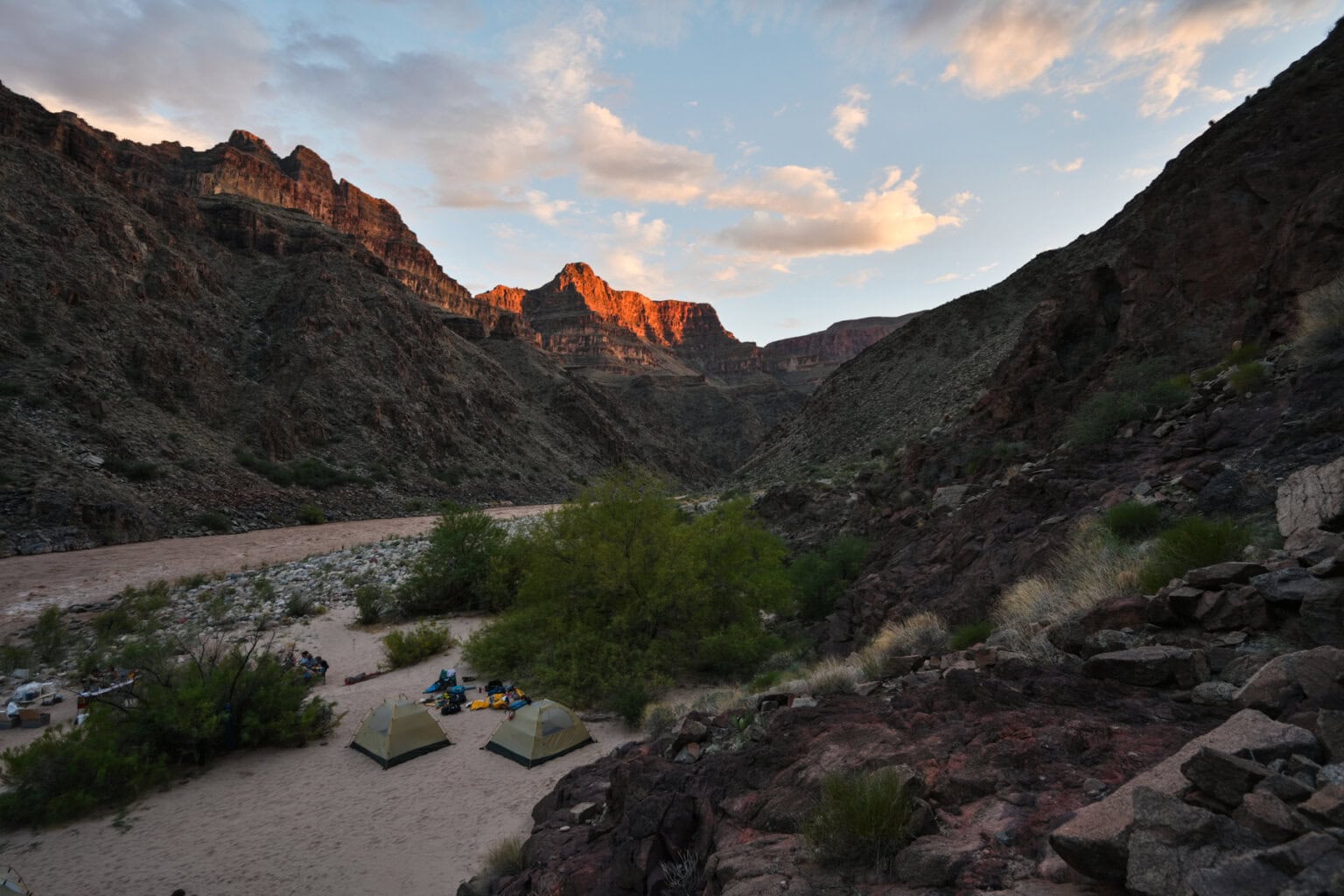 The sun sets on canyon walls at camp along the Colorado River in Grand Canyon