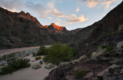 The sun sets on canyon walls at camp along the Colorado River in Grand Canyon