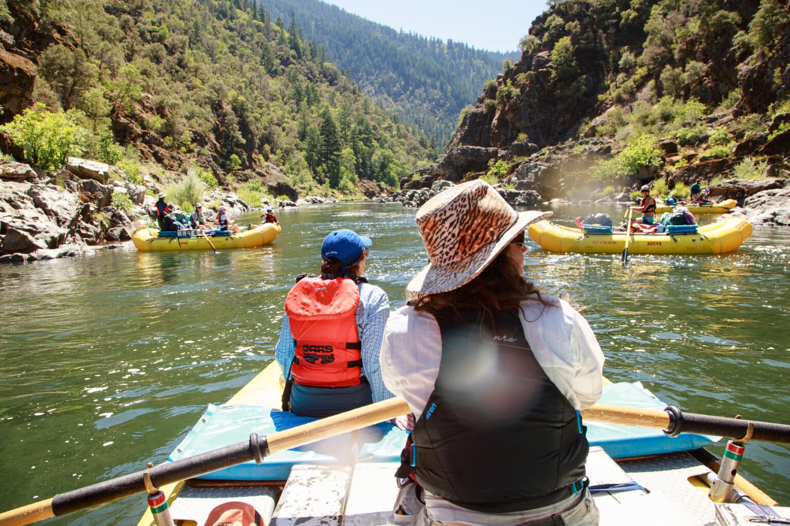 A guide looks to her side as she rows a passenger downstream on the Rogue River in Oregon