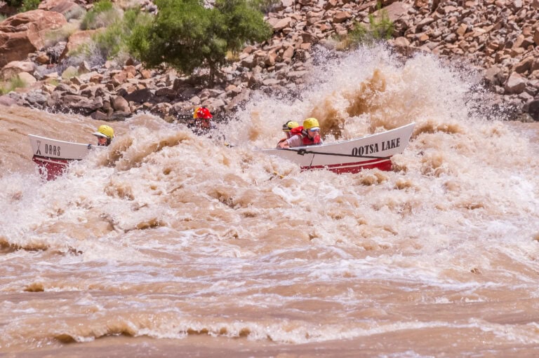 A dory plows through a big rapid on the Colorado River in Cataract Canyon, a shorter alternative to a Grand Canyon river expedition