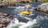Two yellow rafts with a group of paddlers float toward whitewater riffles on the South Fork of the American River