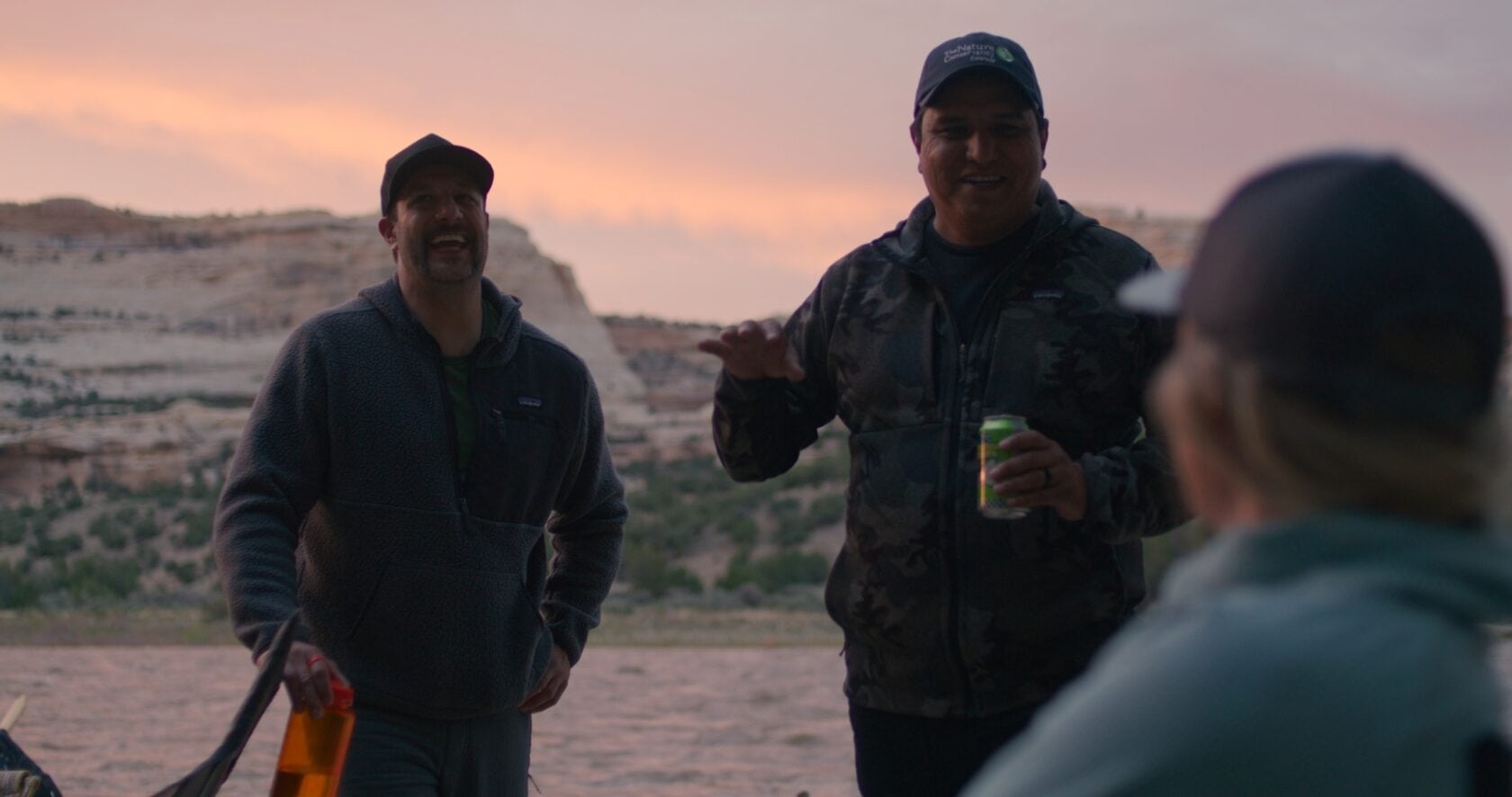 Guests on a rafting trip on the Yampa River share a laugh next to the river.