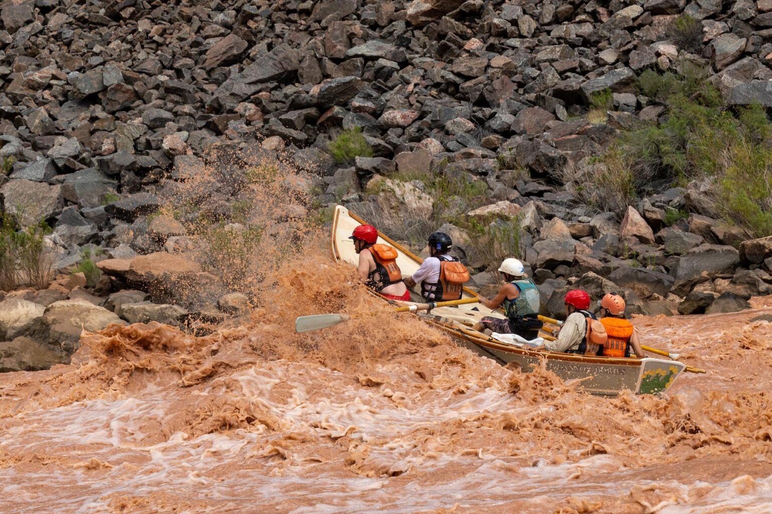 A dory rowed by Cindell Dale splashes through a rapid on the Colorado River through Grand Canyon.