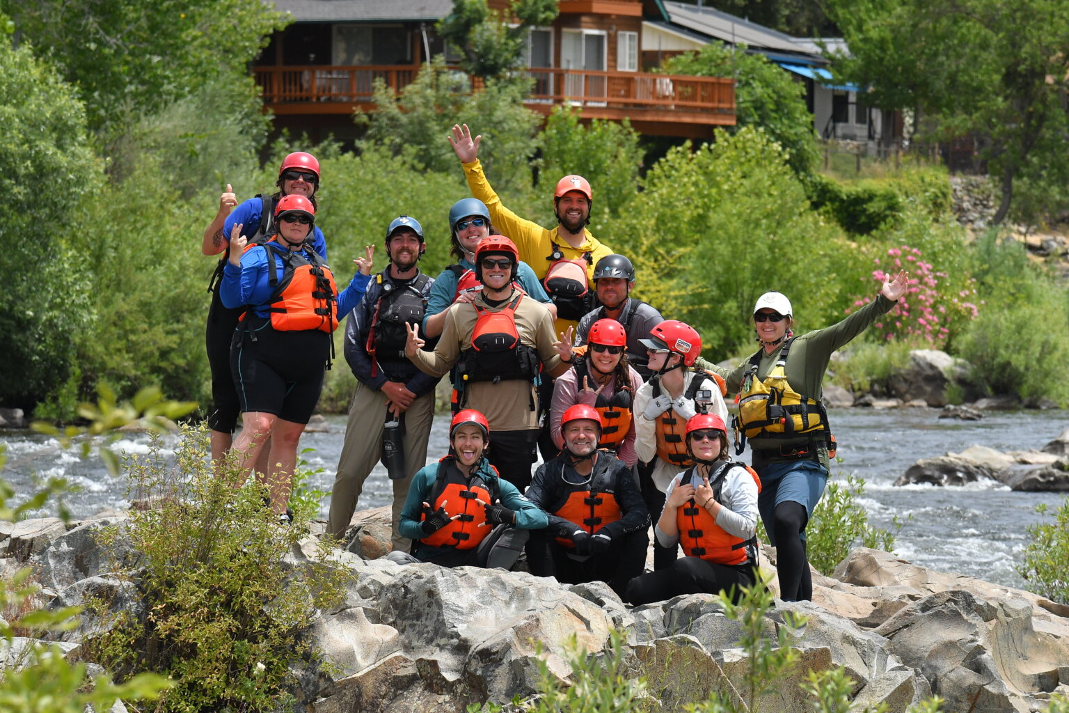 A group of students in an OARS whitewater guide school pose for a photo on the American River.