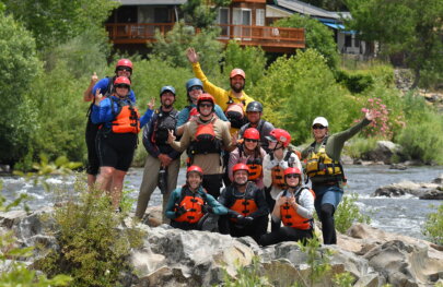 A group of students in an OARS whitewater guide school pose for a photo on the American River.