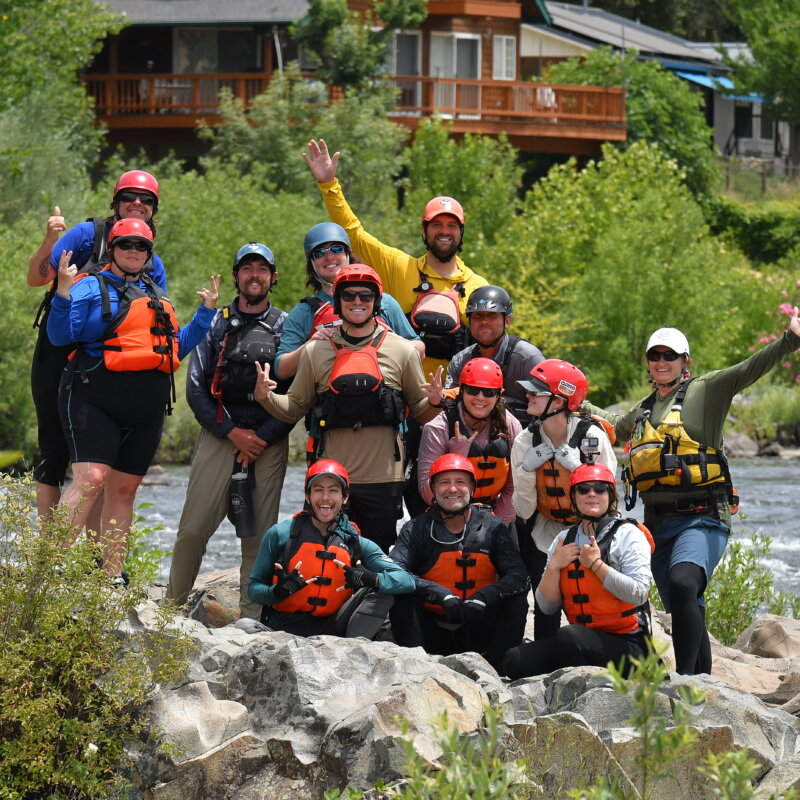 A group of students in an OARS whitewater guide school pose for a photo on the American River.
