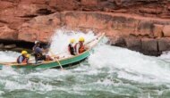 A dory boat goes through a rapid on the Colorado River through Grand Canyon.