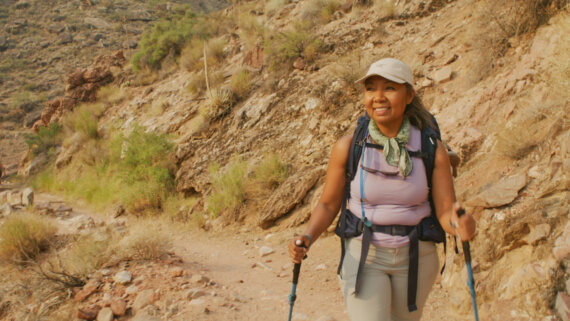 Woman with hiking poles and text that reads: Hiking the Bright Angel Trail