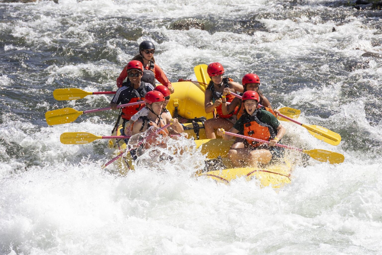 A yellow OARS raft engulfed in a rapid on the South Fork of the American River