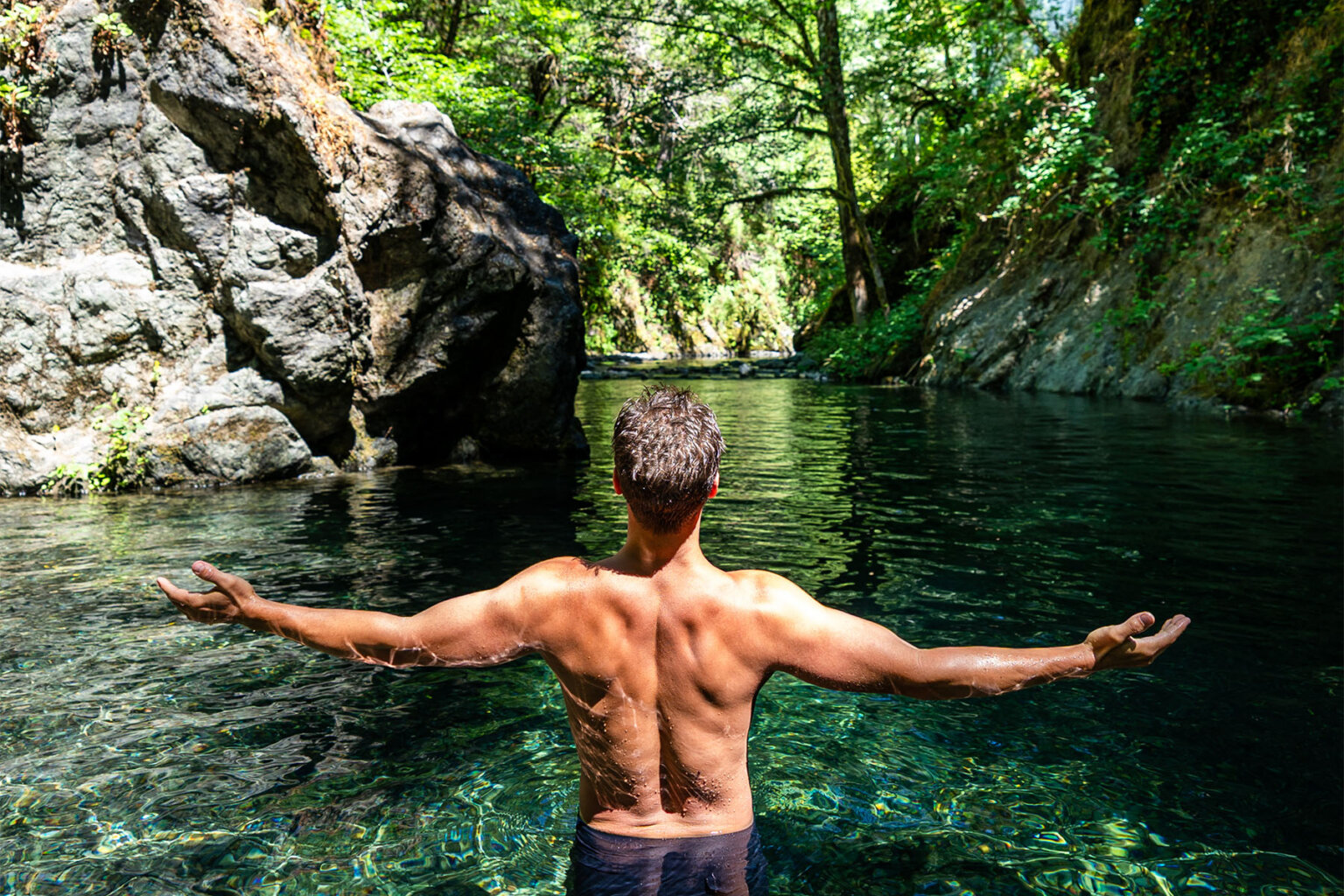 A man enjoys a crystalline swimming hole along Oregon's Rogue River